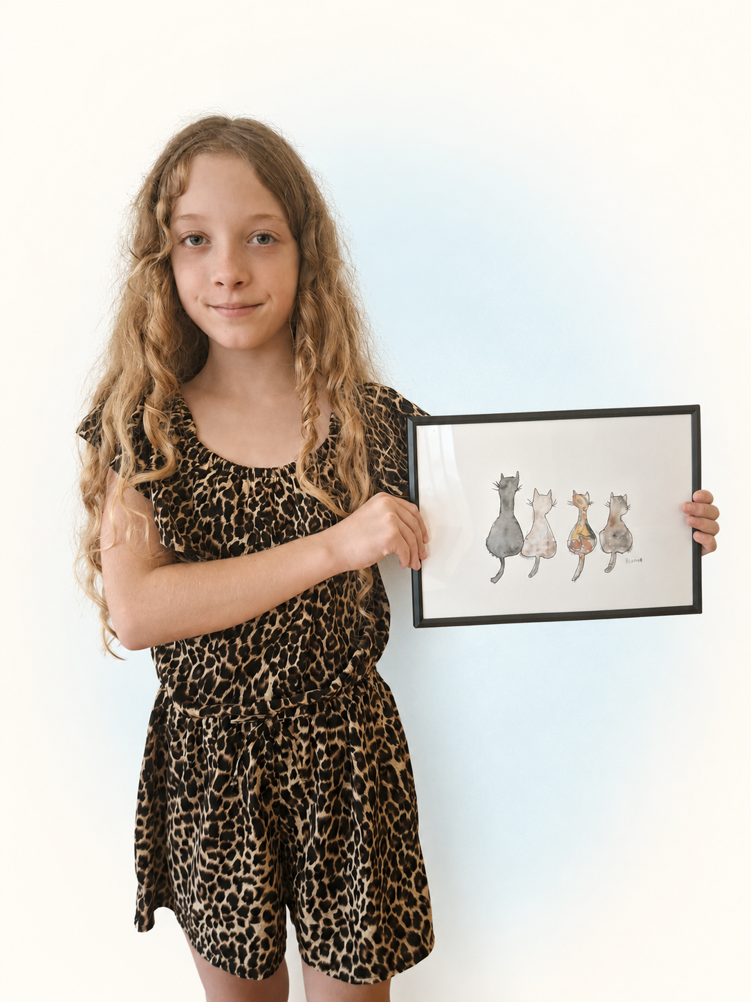 Een deelnemer toont haar ingelijste aquarel van vier katten